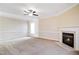 Bright living room with a fireplace, ceiling fan, and large windows for natural light at 211 Whitney Ln, Durham, NC 27713