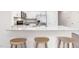 Close-up of the kitchen island featuring a white countertop and three barstools at 235 Perseus St, Angier, NC 27501