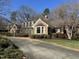 Charming brick home featuring dormer windows, mature landscaping, and a paved driveway at 30 Brookside Place, Durham, NC 27705