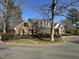 Brick home with a manicured lawn, trees, and a brick driveway at 30 Brookside Place, Durham, NC 27705