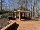 Brick gazebo on a brick patio, surrounded by trees and underbrush, and including a grill at 30 Brookside Place, Durham, NC 27705