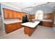 Well-lit kitchen featuring wood cabinets, an island with a stovetop, and a large window at 30 Brookside Place, Durham, NC 27705
