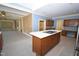 Spacious kitchen with central island, custom wood cabinets, and adjacent living space at 30 Brookside Place, Durham, NC 27705
