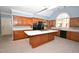 Bright kitchen with hardwood cabinets, center island with cooktop, and modern appliances at 30 Brookside Place, Durham, NC 27705