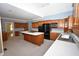 Open kitchen with wood cabinetry, modern appliances, and a central island with cooktop at 30 Brookside Place, Durham, NC 27705