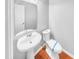 Bathroom with a pedestal sink, a toilet with blue protective cover, and wood floors at 405 Ganyard Farm Way, Durham, NC 27703