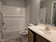 Bright bathroom featuring a tub with tile surround, modern sink, and a large mirror at 4300 Mantua Way, Raleigh, NC 27604