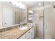 Bathroom featuring walk-in shower with glass door and a vanity with a granite countertop at 4409 Driftwood Dr, Raleigh, NC 27606