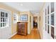 Hallway with beautiful wood floors, leading to an office area, and showcasing natural light from a window at 4409 Driftwood Dr, Raleigh, NC 27606