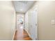 Hallway with hardwood floors, two white doors and neutral colored walls, with a glimpse of a living area at 4409 Driftwood Dr, Raleigh, NC 27606