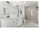 Bright bathroom featuring a double vanity, modern lighting, and glass-enclosed shower with neutral tile at 46 N District Ave # 251, Clayton, NC 27527