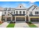 Charming townhome exterior boasts brick accents, a two-car garage, and a well-manicured lawn at 46 N District Ave # 251, Clayton, NC 27527