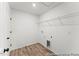 Bright laundry room with wood-look flooring and shelving for storage at 46 N District Ave # 251, Clayton, NC 27527