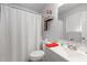 Well-lit bathroom with a toilet, sink, and white textured shower curtain at 5108 Walton Hill Rd, Knightdale, NC 27545