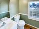 This bathroom has a tiled floor, with a single sink, white toilet, and view to the street at 5317 Tifton Dr, Raleigh, NC 27610