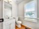 Cozy powder room featuring wood floors, a sink, and a toilet at 5317 Tifton Dr, Raleigh, NC 27610