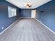 This bedroom has blue walls, a ceiling fan, and neutral carpet at 5317 Tifton Dr, Raleigh, NC 27610