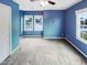 This blue bedroom has two windows, a ceiling fan and neutral carpet at 5317 Tifton Dr, Raleigh, NC 27610