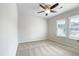 Minimalist bedroom featuring neutral carpet, bright windows, and a ceiling fan at 5317 Tifton Dr, Raleigh, NC 27610