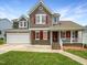 Charming two-story home with a manicured lawn, attached garage, and inviting front porch at 5317 Tifton Dr, Raleigh, NC 27610