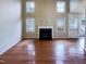 Spacious living room featuring hardwood floors, fireplace, and large windows at 5317 Tifton Dr, Raleigh, NC 27610