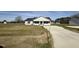 Charming single-story home with a well-manicured lawn and a long concrete driveway, all under a bright blue sky at 57 Faucette Dr, Selma, NC 27576
