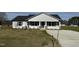 Inviting home exterior with stone accents and a covered entrance, surrounded by newly planted landscaping at 57 Faucette Dr, Selma, NC 27576
