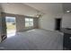 Spacious living room featuring plush carpet, a modern ceiling fan, and bright windows, creating a cozy atmosphere at 57 Faucette Dr, Selma, NC 27576
