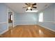 Large light blue bedroom with hardwood floors, chair railing, and a ceiling fan at 6005 Kim'S Dr, Hurdle Mills, NC 27541