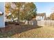 The backyard of the home has a wood fence and mature tree with leaves on the ground at 605 Stratton Way, Durham, NC 27704