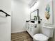 Stylish bathroom with white vanity, black hardware, and wood-look flooring at 606 E Pearsall St, Dunn, NC 28334