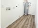 Utility room with wood-look flooring, water heater and washer-dryer hookups at 606 E Pearsall St, Dunn, NC 28334
