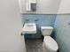 A full bathroom with blue tile, toilet and sink at 623 Sybil Dr, Durham, NC 27703