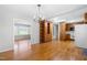 Open-concept dining area with hardwood floors, a stylish chandelier, and convenient access to the kitchen at 6500 Brandywine Rd, Raleigh, NC 27607