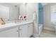 Fresh bathroom featuring white vanity, a stylish mirror, and a shower with blue tile at 748 Shady Lawn Rd, Chapel Hill, NC 27514