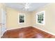 This bedroom features beautiful hardwood floors, two windows, and a ceiling fan at 816 Carolina Ave, Durham, NC 27705