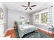Serene bedroom with a ceiling fan, hardwood floors, and natural light from the windows at 816 Carolina Ave, Durham, NC 27705