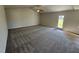 Spacious living room featuring plush carpeting, neutral walls, ceiling fan and a door leading to the outdoors at 90 Pate Landing Dr, Selma, NC 27576