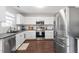 Bright kitchen features stainless steel appliances, granite counters, and ample white cabinetry at 1005 Cookwood Ct, Raleigh, NC 27610