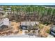 An aerial view of townhomes, showcasing their layout, landscaping, and proximity to surrounding wooded areas and a lake at 107 Vickery Hill Ct, Durham, NC 27703
