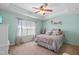 Bright bedroom features a tray ceiling, soft decor, and a view of the yard from the window at 107 Vickery Hill Ct, Durham, NC 27703