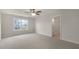 A carpeted bedroom with a ceiling fan, and a view through the window. It has an ensuite bathroom at 129 Paper Birch Way, Fuquay Varina, NC 27526