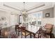 Elegant dining room with wainscoting, a modern chandelier, and a large window with plantation shutters at 1301 Mackinaw Dr, Wake Forest, NC 27587