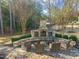 Charming stone fireplace and firepit area with comfortable seating, perfect for outdoor gatherings and relaxation at 1301 Mackinaw Dr, Wake Forest, NC 27587