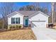 Charming one story home featuring a brightly colored door, inviting curb appeal and an attached two-car garage at 138 Clear Water Rd, Louisburg, NC 27549