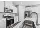 Kitchen featuring an island with sink, stainless steel appliances, white cabinets, and modern finishes at 138 Clear Water Rd, Louisburg, NC 27549