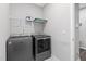 Modern laundry room equipped with a washer, dryer, and overhead storage at 138 Clear Water Rd, Louisburg, NC 27549