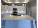 Modern kitchen with white cabinets, stainless steel appliances, and a large quartz island at 138 Oban Dr, Homesite 134, Sanford, NC 27330