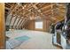 Unfinished attic space featuring exposed wood beams and a window for natural light at 140 Southern Acres Dr, Fuquay Varina, NC 27526