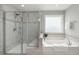 Bathroom featuring a soaking tub, glass shower, and elegant tile accents at 140 Southern Acres Dr, Fuquay Varina, NC 27526